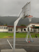 Basketball post and hoop tower with adjustable height from senior to junior, on an outdoor court with mountains in the background