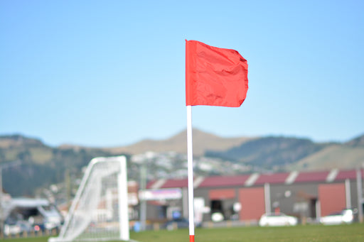 White football corner pole with red flag