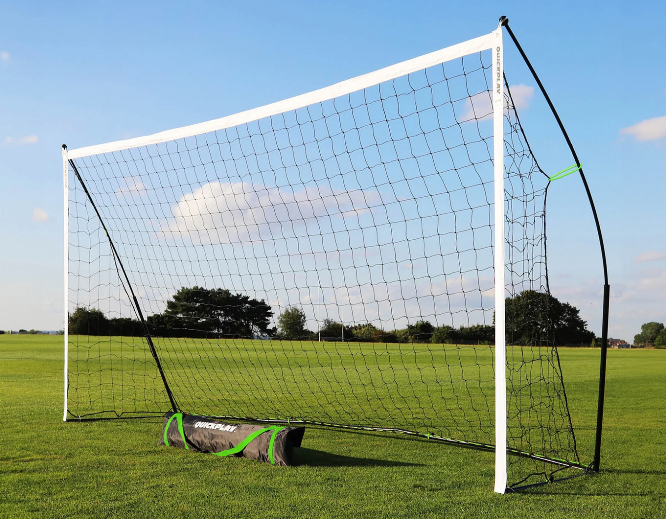 Football goal on a grass field with carry bag, on a clear blue sky