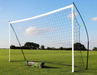 Football goal on a grass field with carry bag, on a clear blue sky