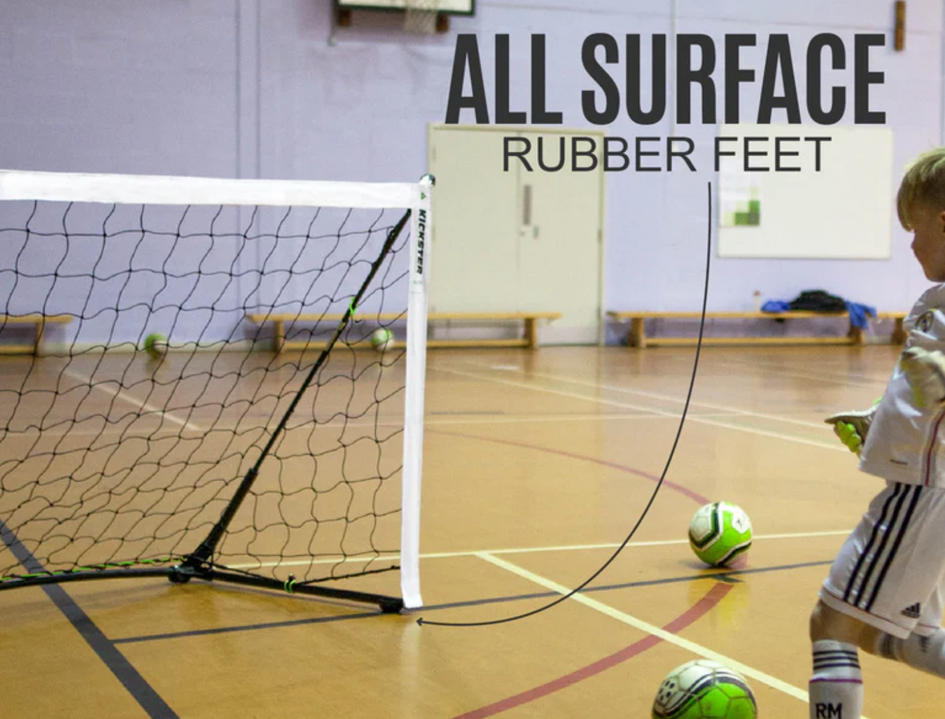 Child playing with a soccer ball on a wooden floor with 'All Surface Rubber Feet' text in the background.